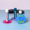 Three vibrant color combinations of the vinyl record lip balm holders including cyan blue, magenta pink, and purple