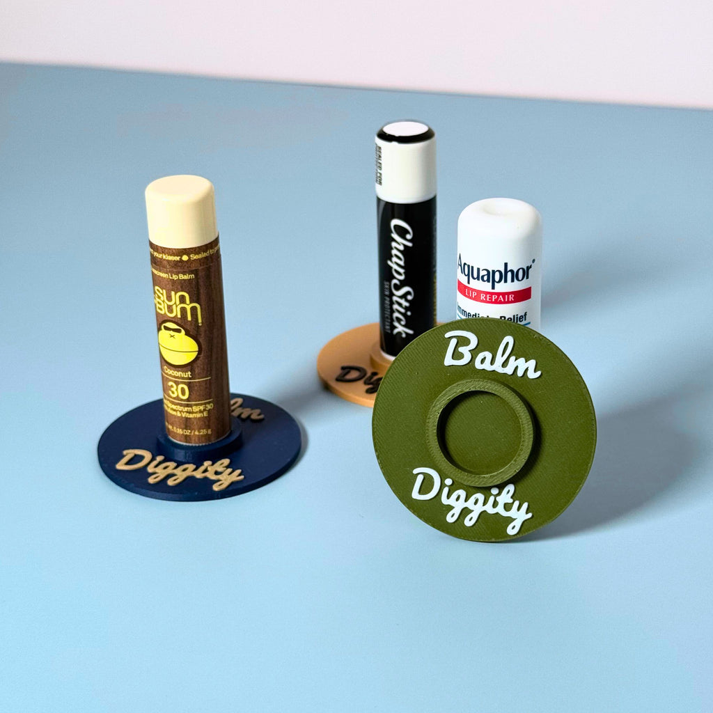 Three color combinations of the vinyl record lip balm holders including olive, beige, and navy blue