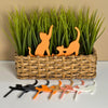 Cute set of orange cat plant stakes stretching and playing inside a houseplant with 6 color options in front of it