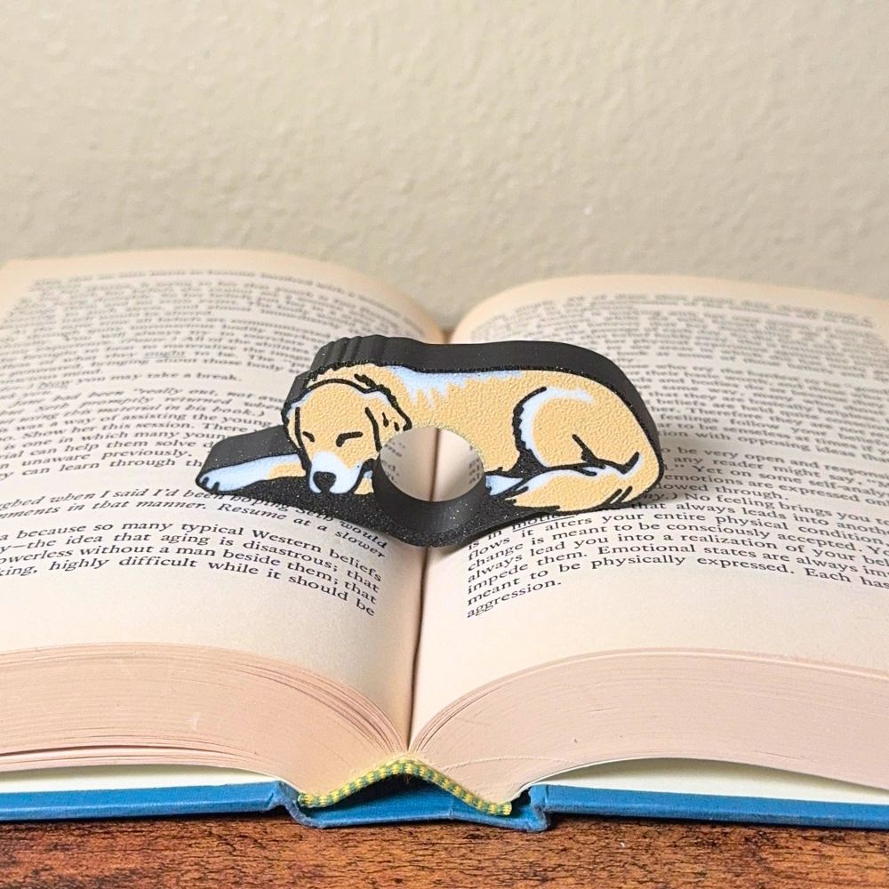 Adorable sleeping tan and white golden retriever dog book page holders shown in a book