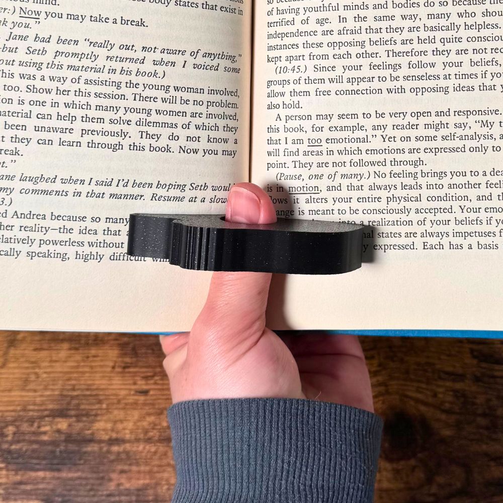 Adorable sleeping gold and white fur golden retriever dog book page holder shown holding a book open from the top view