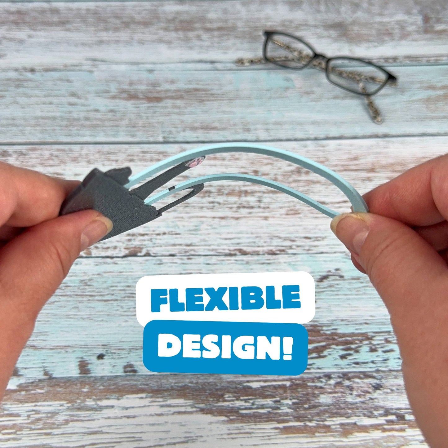 Gray tuxedo cat bookmark being bent, showing off its flexible design