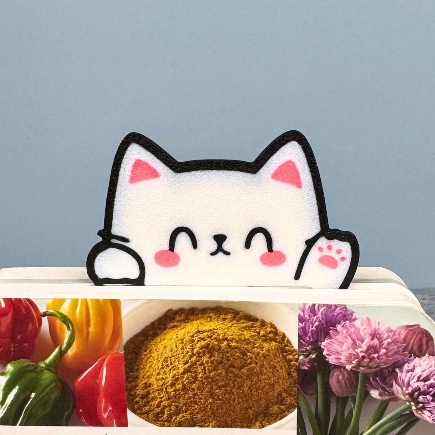 Adorably cute Kawaii cat bookmark peeking out of a book