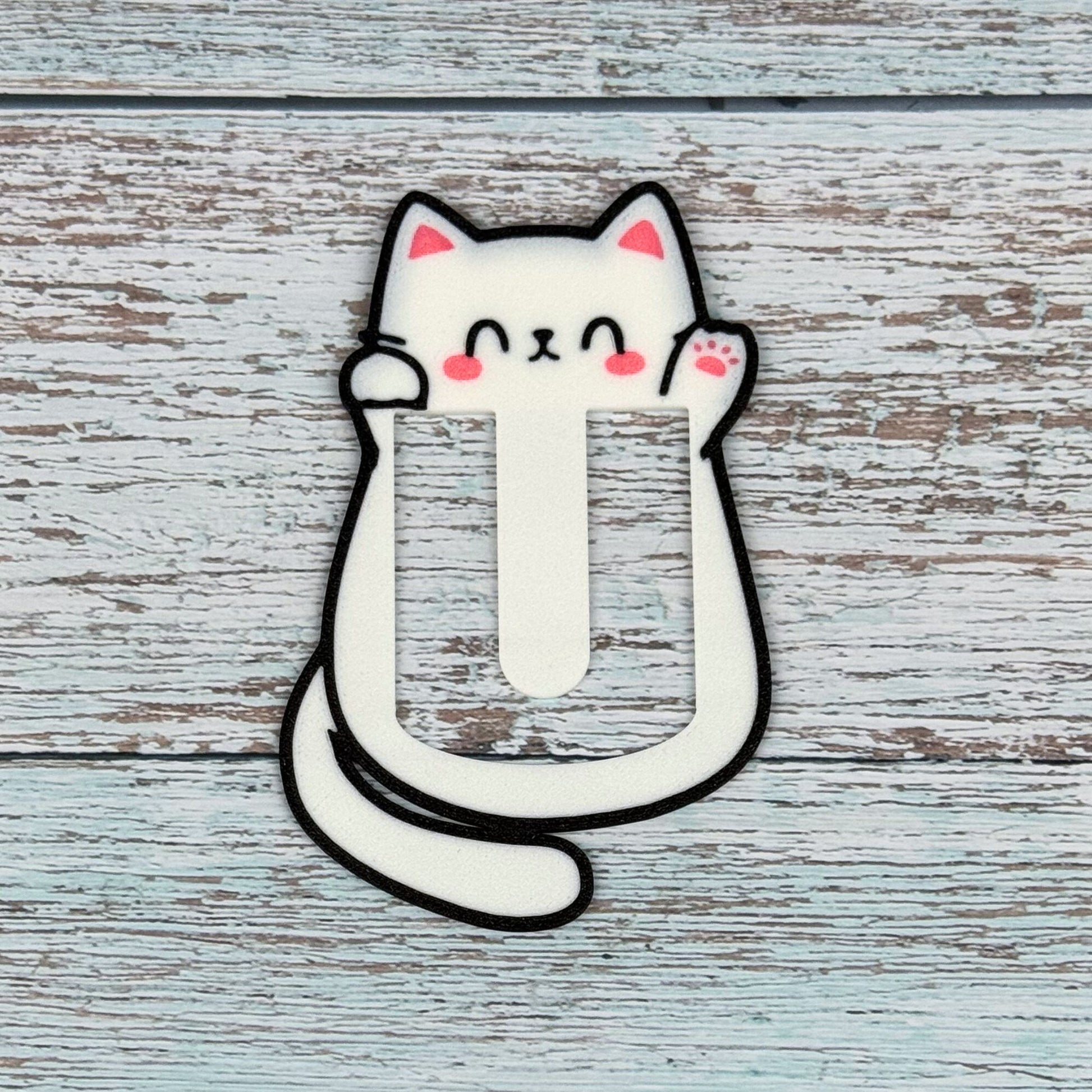 Cute kawaii style cat bookmark on a blue wooden surface