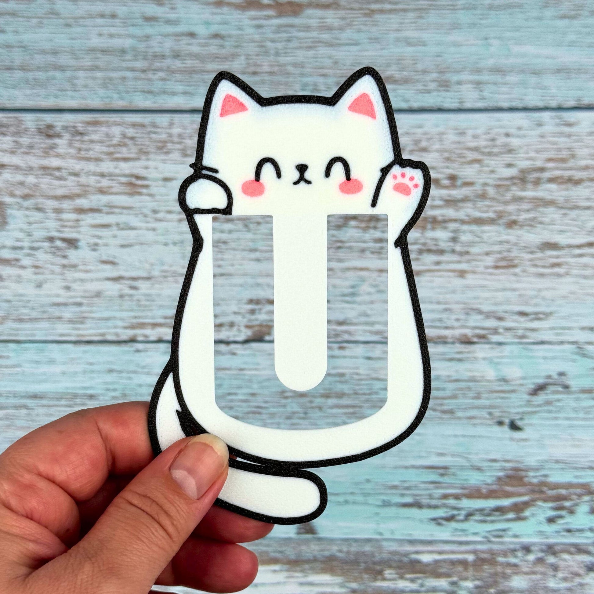 Woman holding a Kawaii cat bookmark waving hello