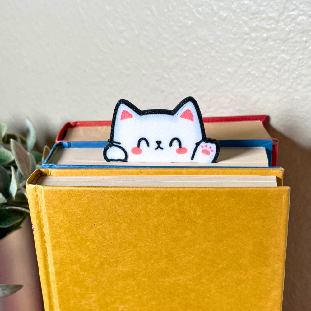 Cute kawaii style cat bookmark waving hello from a stack of colorful books