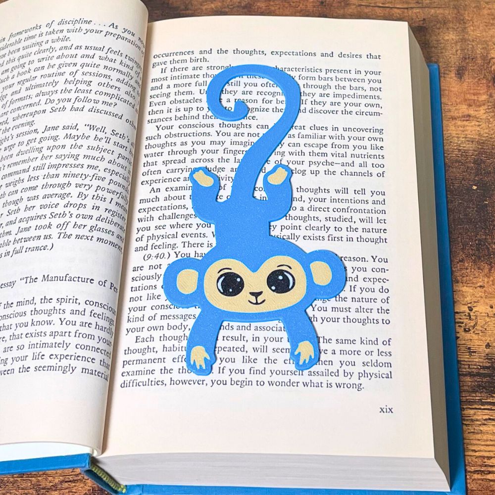 Fun blue monkey bookmark inside of a book