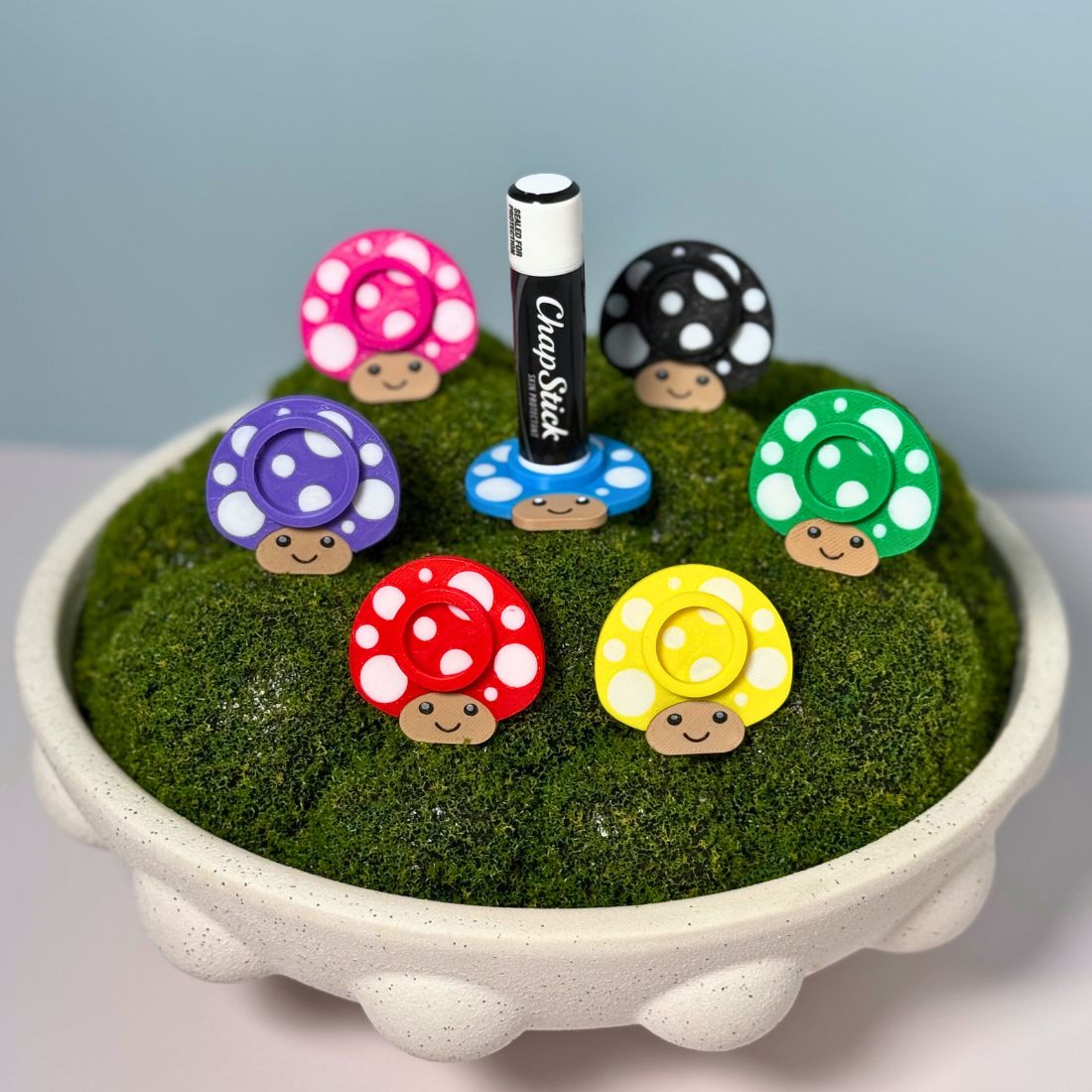 Seven color options for the mushroom lip balm stands including black, red, yellow, green, blue, pink, and purple.