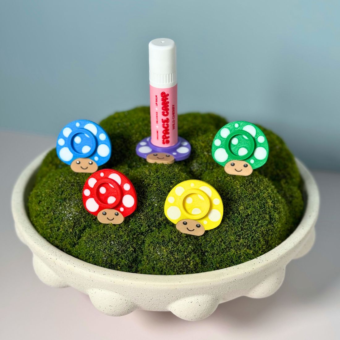 Five color options for the mushroom lip balm stands including red, yellow, green, blue, and purple.