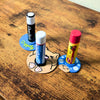 Video showing how the lip balm stands work. Not tipping over when sliding across a table or rolling off your side table under the bed