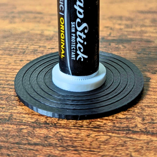 Black and white vinyl record lip balm stand holding a chapstick up