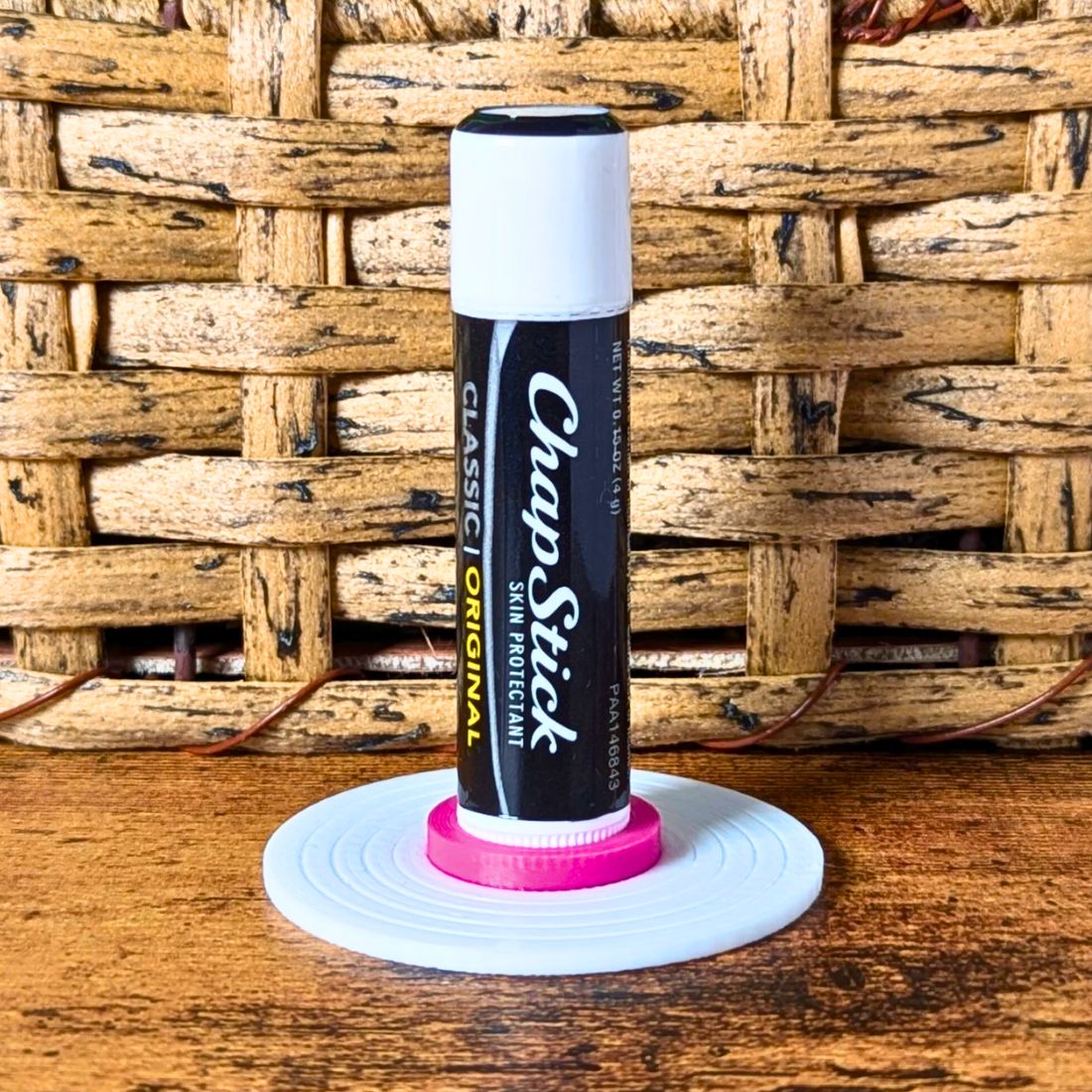 White and pink vinyl record lip balm stand holding a chapstick up