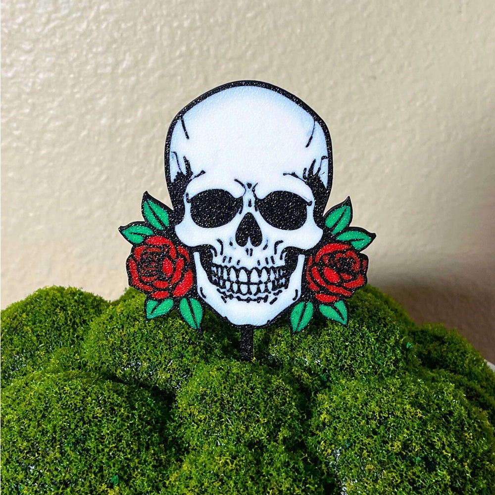 Gothic skull head with red roses on each side shown in a moss houseplant