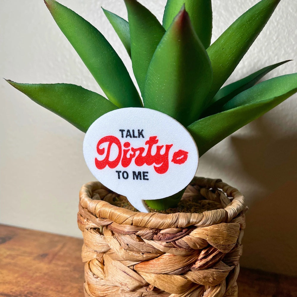 The punny Talk Dirty to Me plant stake in a houseplant closer up