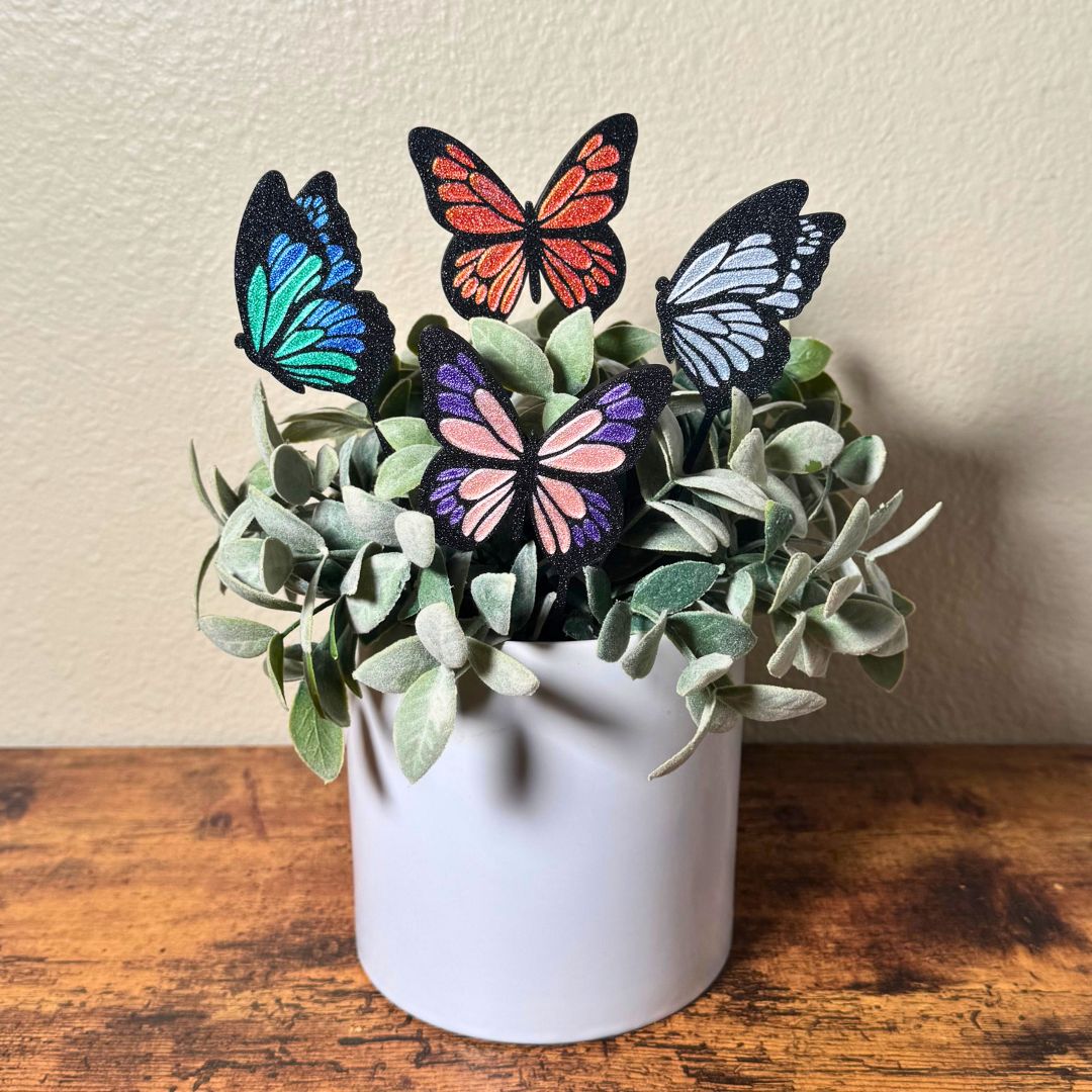 4 color variations of the tall butterfly plant stakes in a potted indoor plant