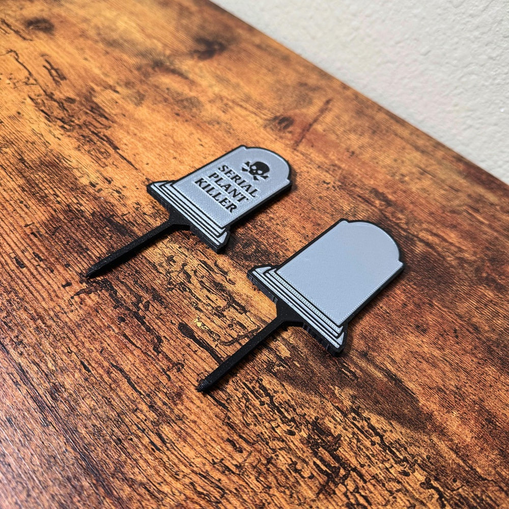 Two tombstone plant stakes showing the front and back of the product from an angle