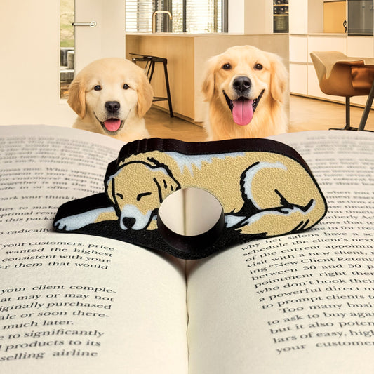 Two golden retrievers sit happily in a cozy modern kitchen behind an open book featuring a Labrador and Golden Retriever themed reading comfort ring that holds the pages open with you. Perfect for pet parents and book lovers, this handcrafted book accessory doubles as charming bookshelf and book nook decor.