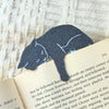Gray cat-shaped bookmark on an open book