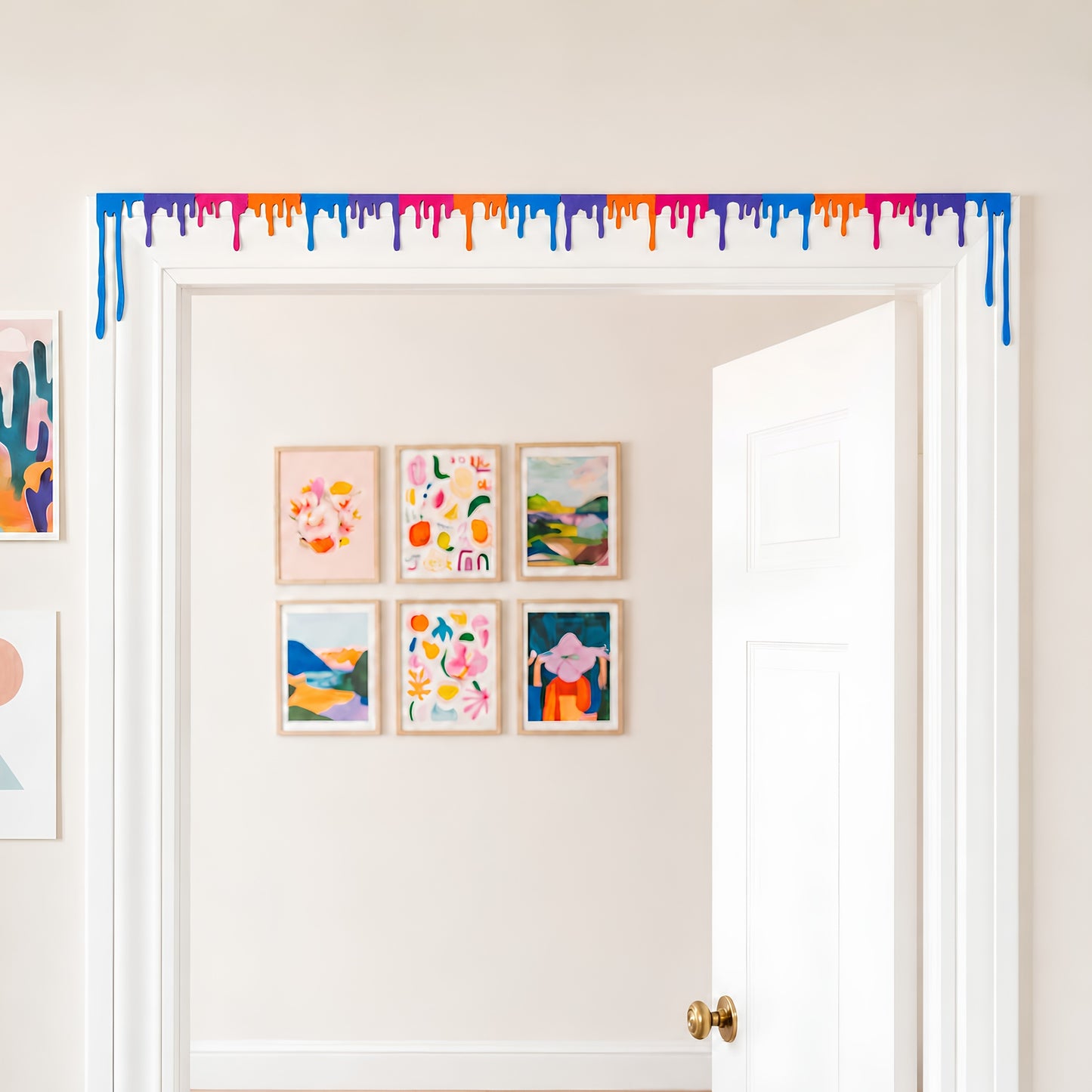 Multicolor liquid drip door topper spanning the full top trim of a white doorway with a gallery wall behind