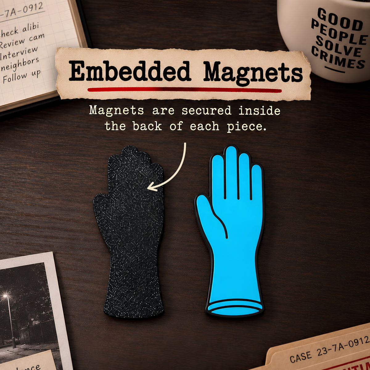 Two glove-shaped magnets on a dark wooden desk, one black textured and one blue, with text reading 'Embedded Magnets' and an arrow pointing to the back of the glove.
