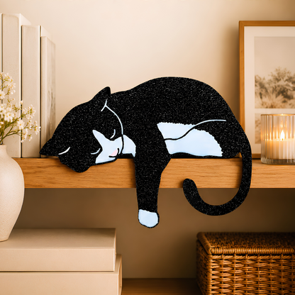 Tuxedo cat shelf pet draped over a wooden shelf edge, black and white cat decor with candle and frame