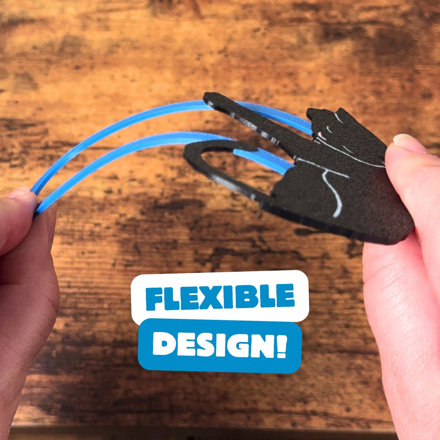 Black cat bookmark being bent, showing off its flexible design