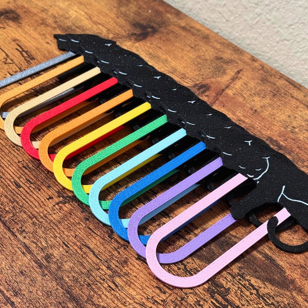 Close up of black cat bookmarks arranged in a row showing off all the color options