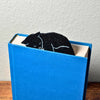 Black cat bookmark shown in a closed book taking a nap on top