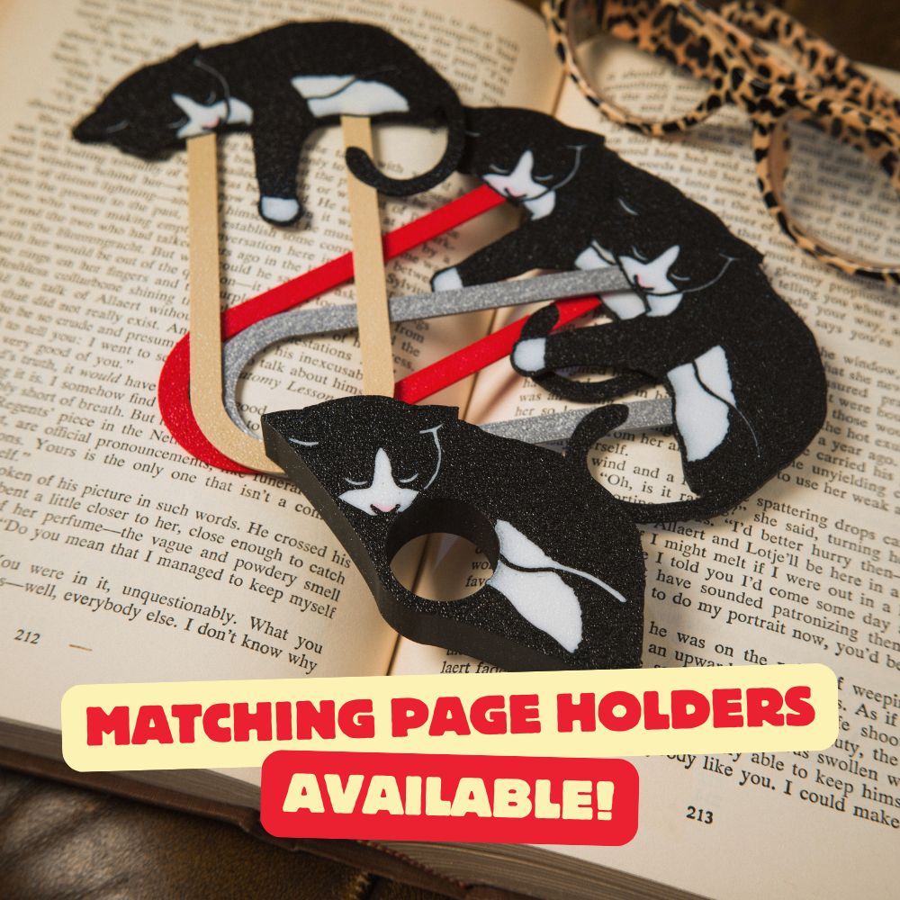 Matching Tuxedo Cat Bookmarks and Page Holders Shown Laying on top of an Open Book with Cheetah Glasses in the Background