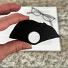 Back of the product showing an all black color held by a hand with a blurred background