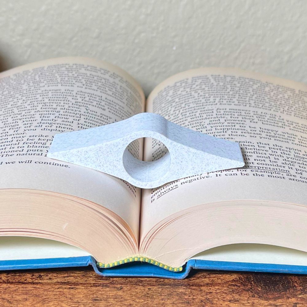A marble book page holder laying in the middle of an open book