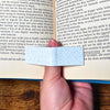 A marble book page holder holding a book open showing off its functionality