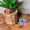 Cute mushroom plant stakes shown in 5 color variations with adorable smiling faces
