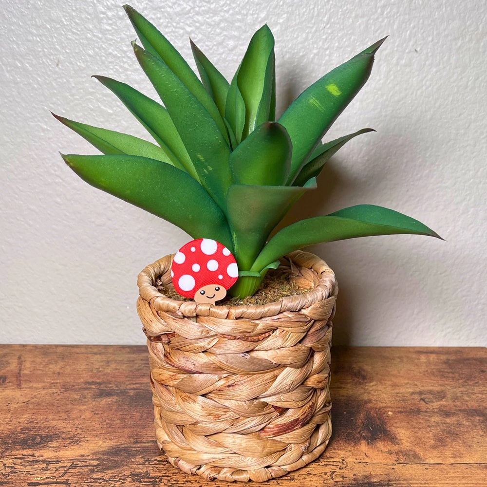 Cute red mushroom plant stake shown in a houseplant