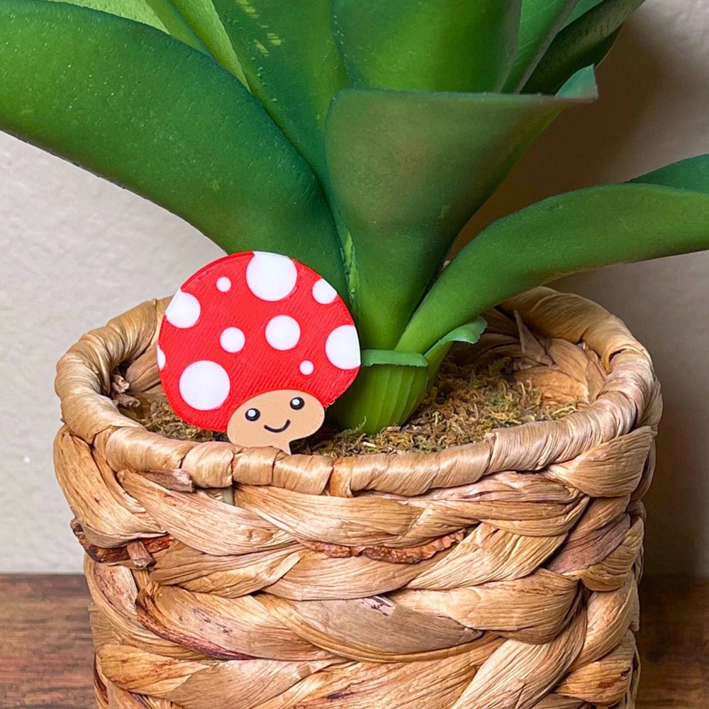 Cute mushroom plant stake shown in red