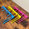 Blue Yellow and Magenta paint dripping door corner wall art laying on a wooden cabinet