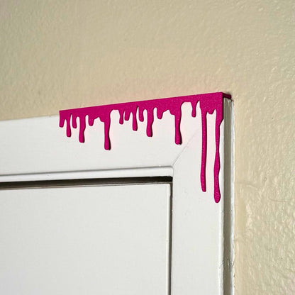 Magenta paint dripping door corner wall art hanging from the right side of the door