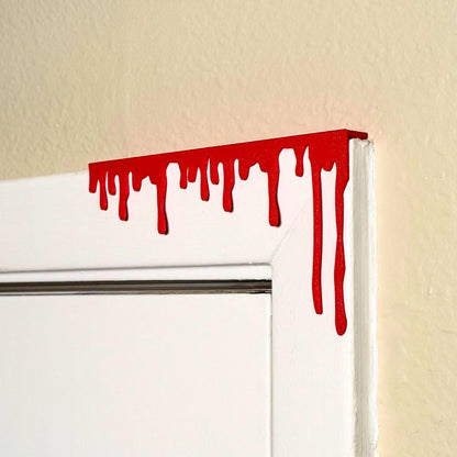 Red paint dripping door corner wall art hanging from the right side of the door
