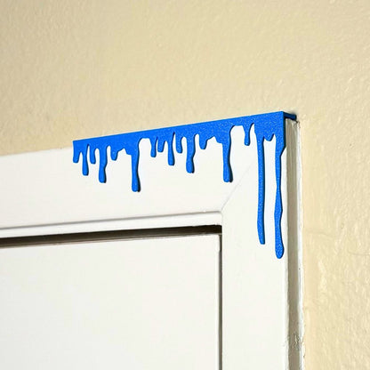 Cyan blue paint dripping door corner wall art hanging from the right side of the door