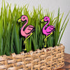 Fun flamingo plant stakes shown in a houseplant from an angle