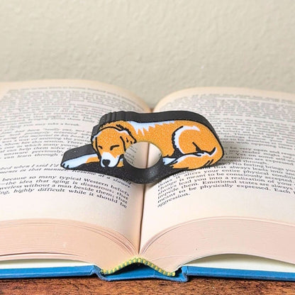 Adorable sleeping gold and white golden retriever dog book page holders shown in a book