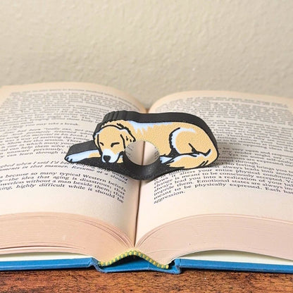 Adorable sleeping tan and white golden retriever dog book page holders shown in a book