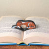 Adorable sleeping brown and white golden retriever dog book page holders shown in a book