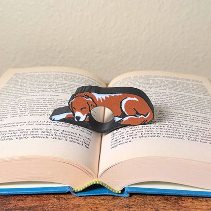 Adorable sleeping brown and white golden retriever dog book page holders shown in a book