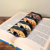 All 4 fur color variations for the sleepy golden retriever dog book page holders shown in a book from the side view