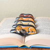All 4 fur color variations for the sleepy golden retriever dog book page holders shown in a book from the front view