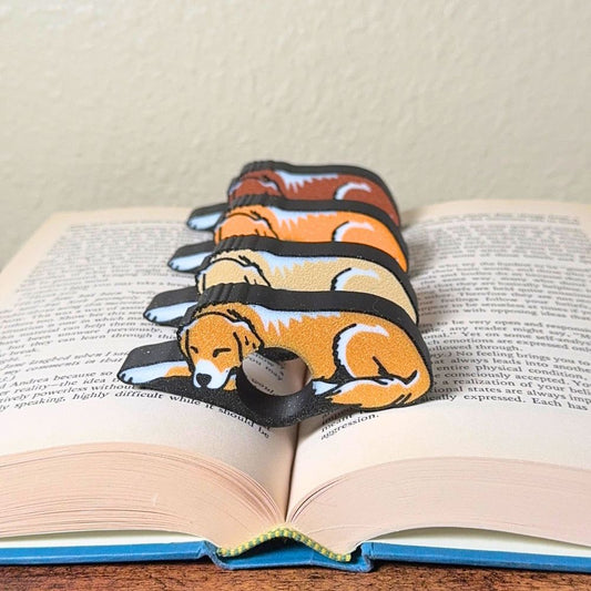 All 4 fur color variations for the sleepy golden retriever dog book page holders shown in a book from the front view