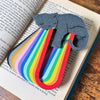 Adorable gray cat-themed bookmarks in twelve color variations stacked in a stack laying on a book