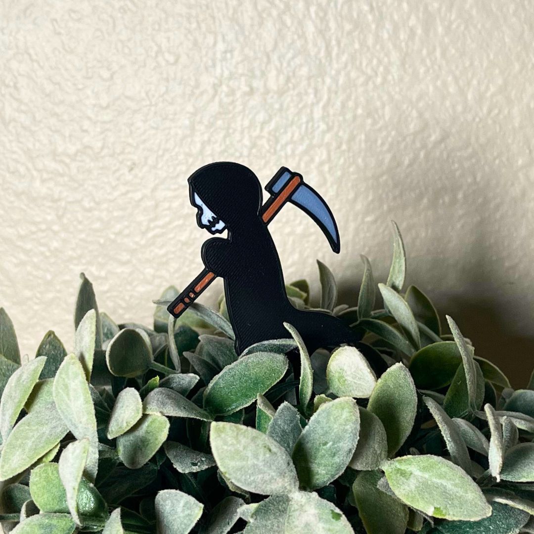 Cute grim reaper plant stake in a houseplant