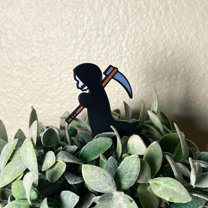Cute grim reaper plant stake in a houseplant